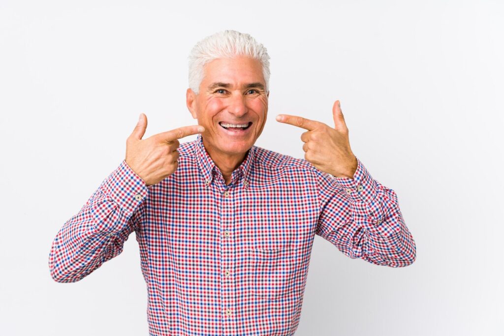Senior caucasian man smiles pointing fingers mouth 1187 70882 Senior caucasian man smiles pointing fingers mouth 1187 70882