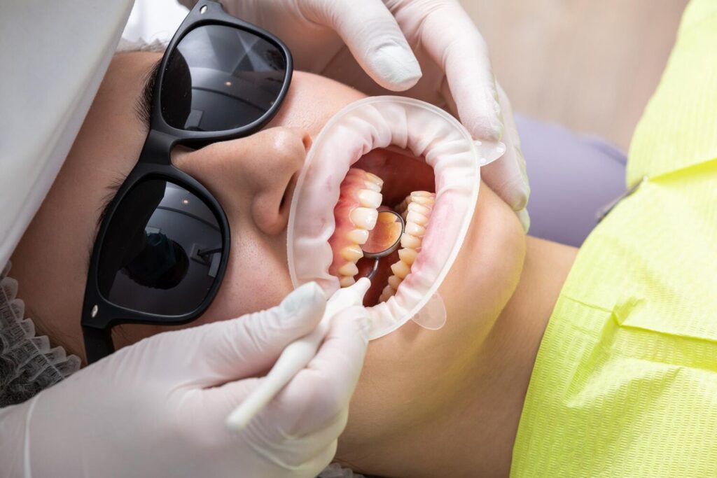Dentist examining patients mouth with dental mirror clinic 130111 8992