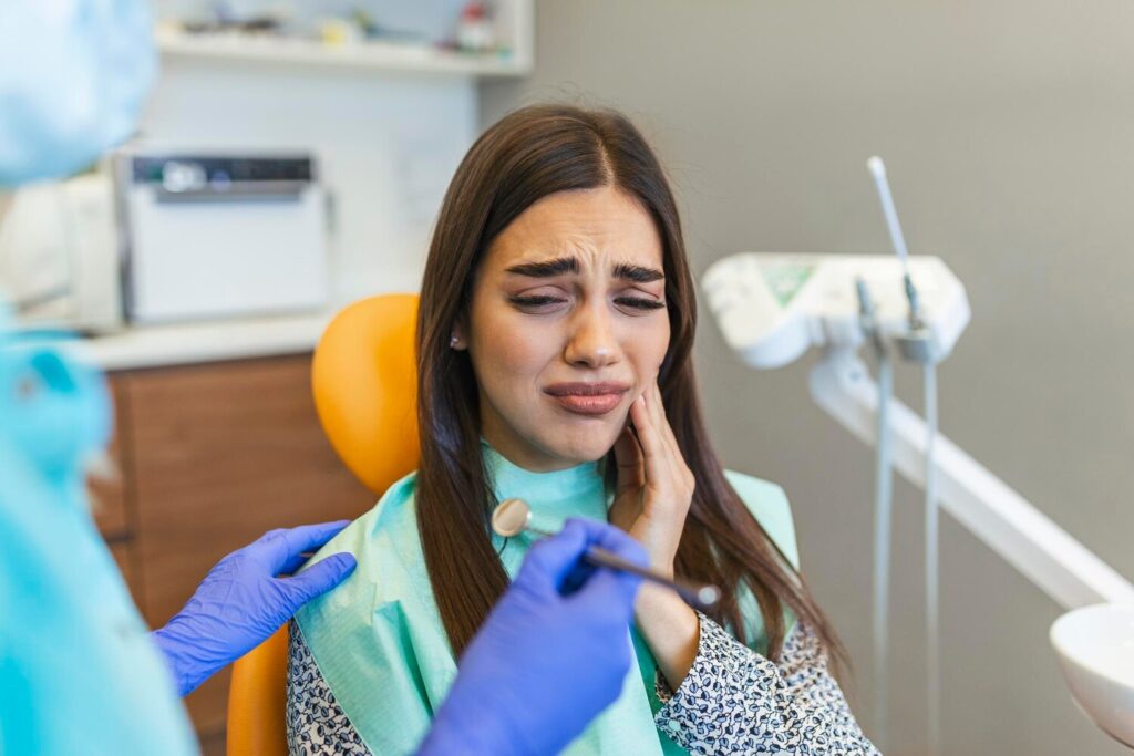 Young woman holding cheek chair dentist having toothache shot young woman suffering from toothache while sitting dentist s chair 1210255 506 Young woman holding cheek chair dentist having toothache shot young woman suffering from toothache while sitting dentist s chair 1210255 506